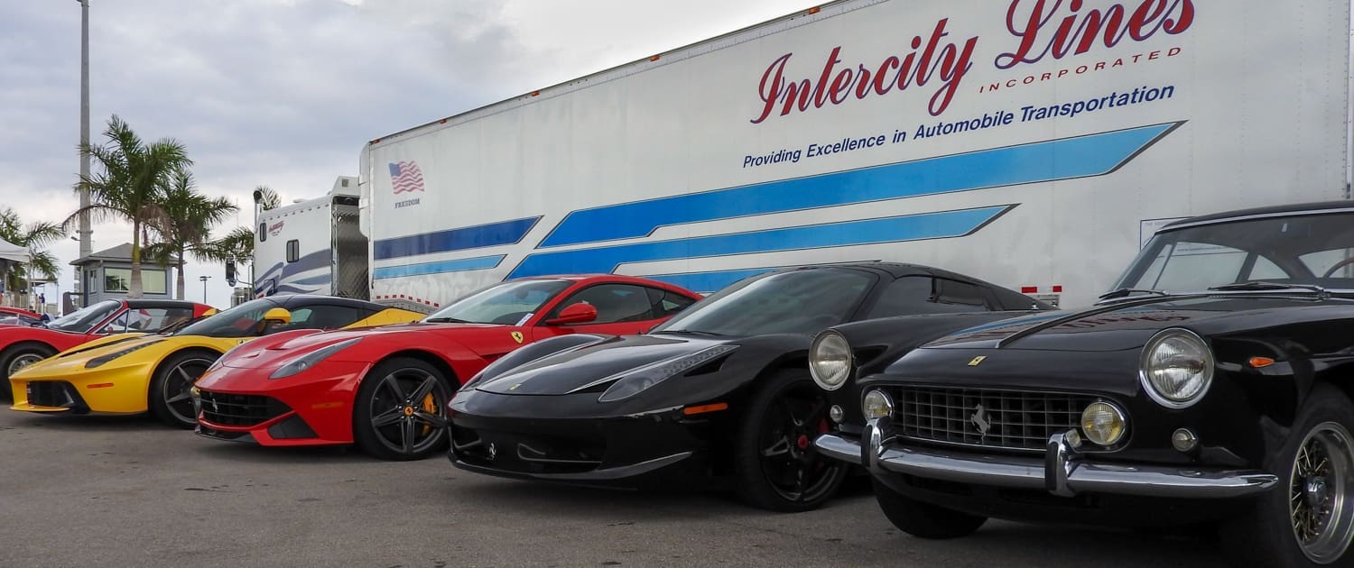 exotic cars in front of a enclosed car trailer